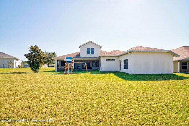 back of property with a lawn