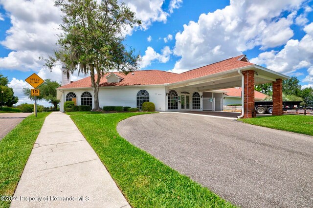 view of front of home with a carport and a front lawn