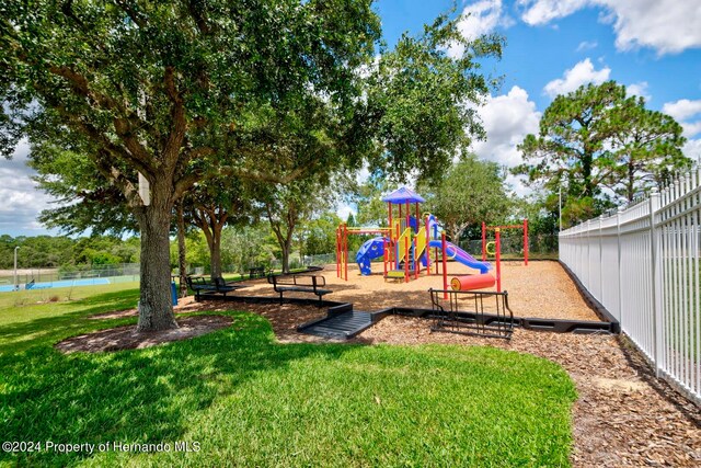 view of play area with a yard and a water view