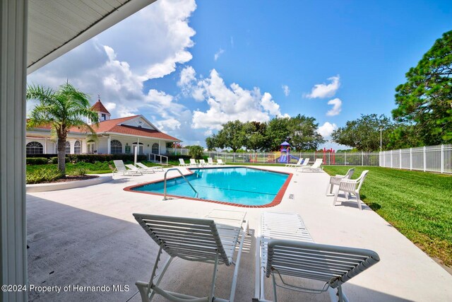 view of swimming pool featuring a yard and a patio