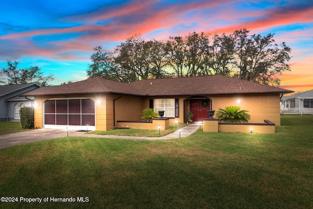 ranch-style house with a garage and a yard