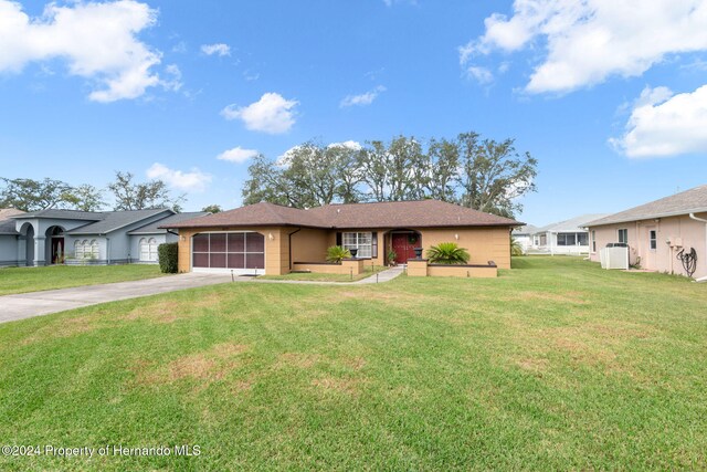 8227 Rhanbuoy Rd, Spring Hill, FL 34606 - ranch-style house featuring concrete driveway, a garage, and a front lawn