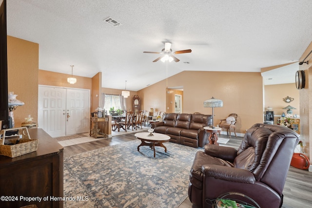8227 Rhanbuoy Rd, Spring Hill, FL 34606 - living room with wood finished floors, vaulted ceiling, a ceiling fan, and a textured ceiling