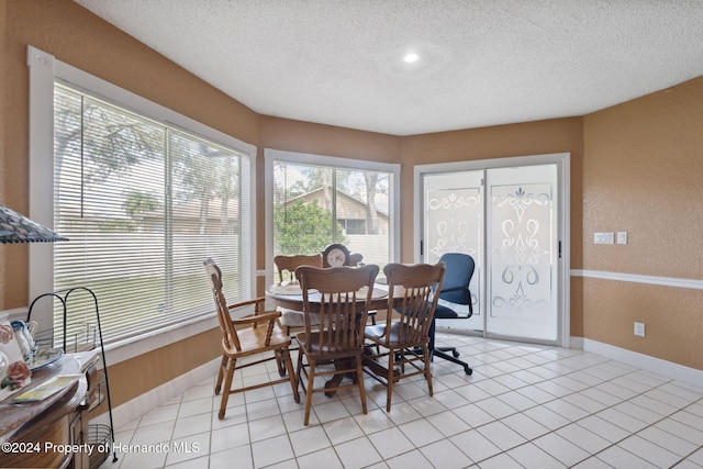 8227 Rhanbuoy Rd, Spring Hill, FL 34606 - dining space featuring a textured ceiling, healthy amount of natural light, light tile patterned floors, and a textured wall