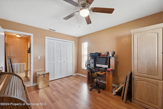 8227 Rhanbuoy Rd, Spring Hill, FL 34606 - home office with light wood-style floors, a ceiling fan, and a textured ceiling