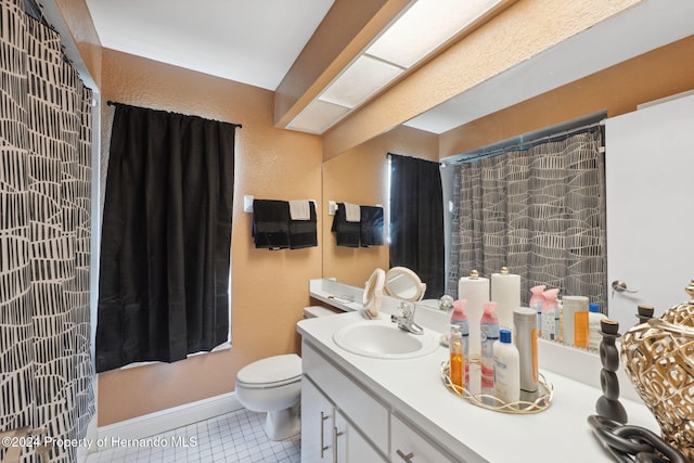 bathroom with toilet, vanity, and tile patterned floors