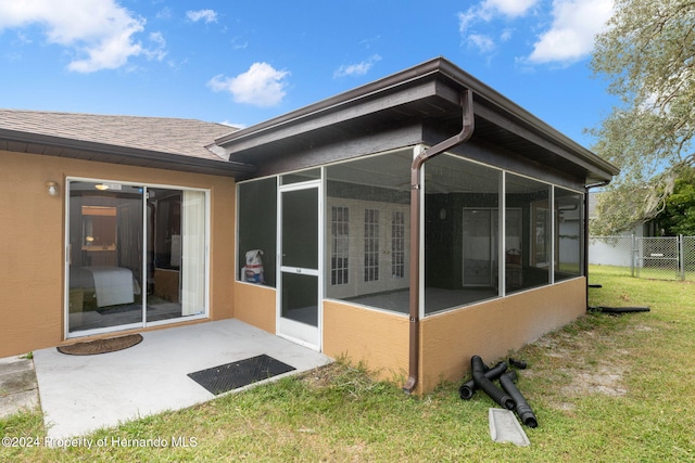 8227 Rhanbuoy Rd, Spring Hill, FL 34606 - back of property featuring a sunroom, a shingled roof, and stucco siding