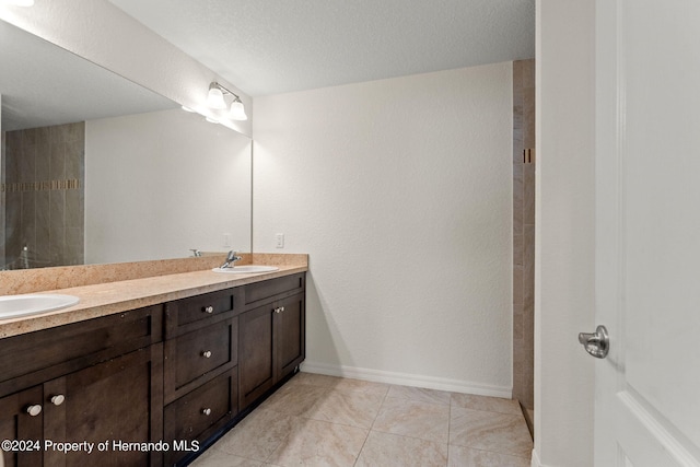 bathroom featuring vanity, a textured ceiling, and tile patterned floors