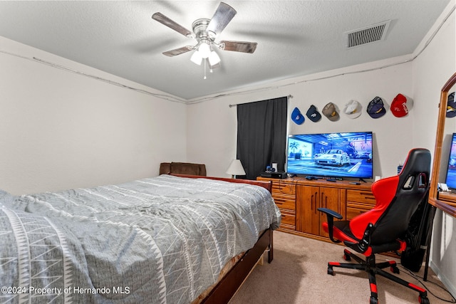 carpeted bedroom featuring a textured ceiling and ceiling fan