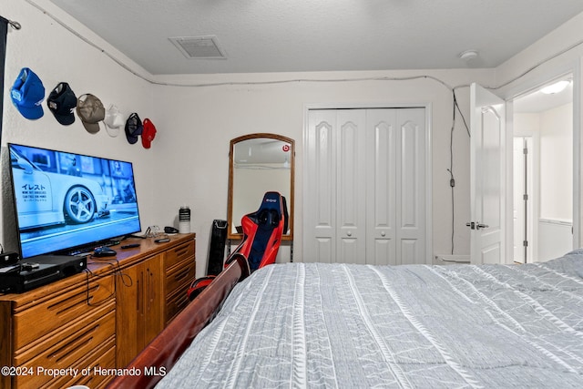 bedroom with a textured ceiling and a closet