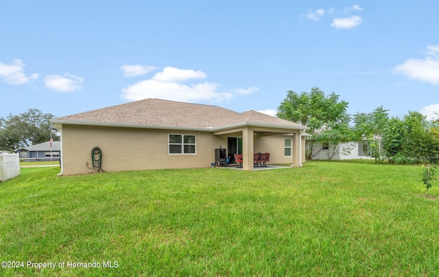 rear view of property with a yard and a patio area