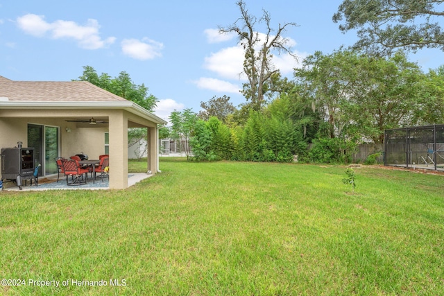 view of yard with ceiling fan and a patio