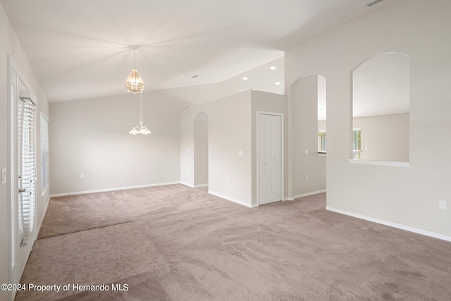 carpeted empty room featuring lofted ceiling