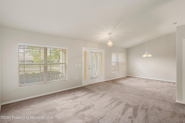 carpeted spare room with vaulted ceiling