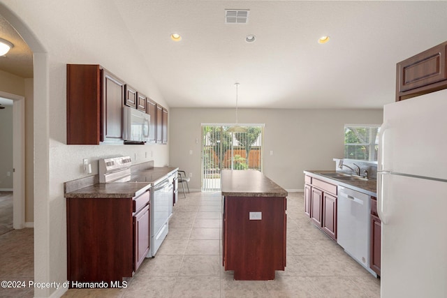 12161 Cavern Rd, Spring Hill, FL 34609 - kitchen with white appliances, a center island, dark countertops, lofted ceiling, and arched walkways