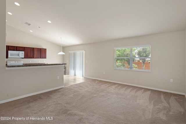 unfurnished living room with high vaulted ceiling and light carpet