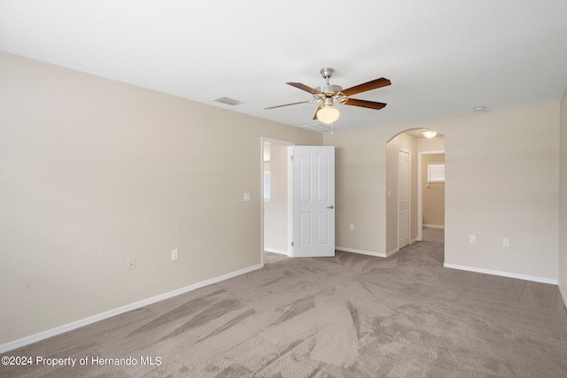 empty room featuring ceiling fan and light carpet