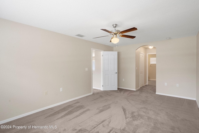 12161 Cavern Rd, Spring Hill, FL 34609 - unfurnished room with arched walkways, ceiling fan, and light colored carpet