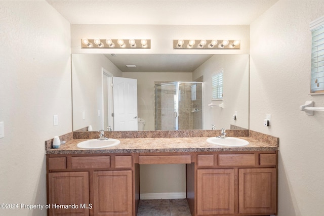 bathroom with walk in shower, vanity, and tile patterned floors