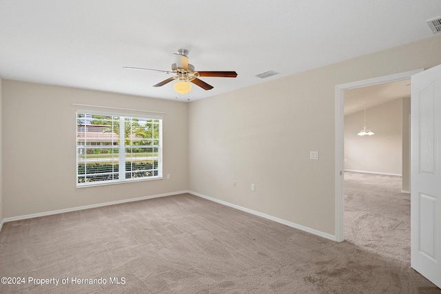 empty room featuring light colored carpet, ceiling fan, and vaulted ceiling