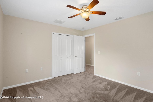 unfurnished bedroom with ceiling fan, a closet, and carpet floors