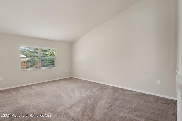 unfurnished room with lofted ceiling and carpet