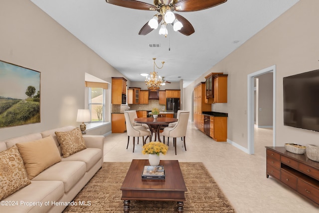 tiled living room with ceiling fan with notable chandelier