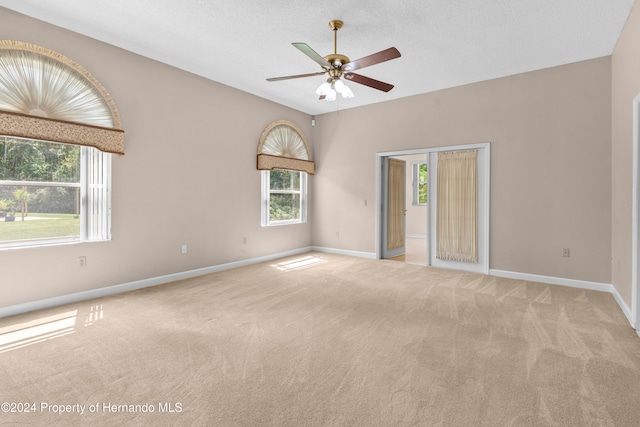 carpeted empty room with a textured ceiling and ceiling fan