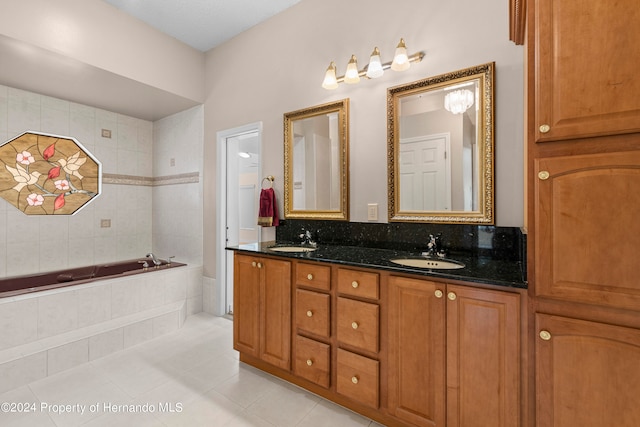 bathroom featuring a relaxing tiled tub, tile patterned floors, and vanity