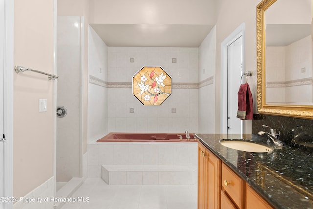 bathroom featuring tiled bath, vanity, and tile patterned floors