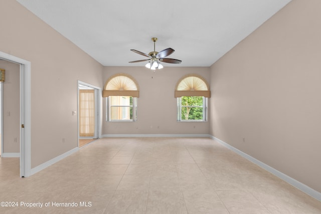 tiled empty room featuring ceiling fan