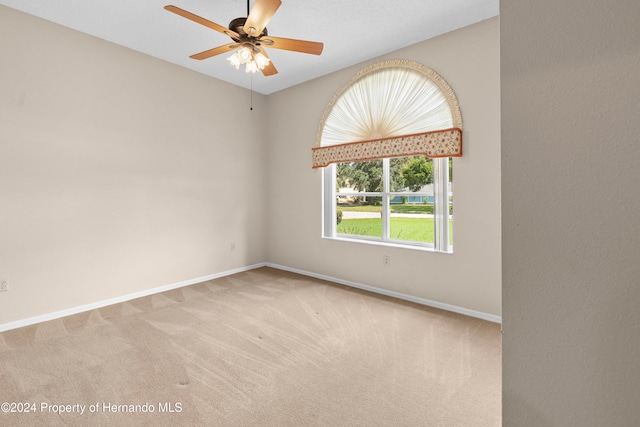 spare room featuring light carpet and ceiling fan