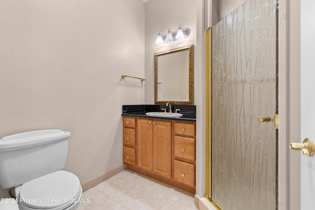 bathroom with tile patterned flooring, vanity, toilet, and a shower with shower door