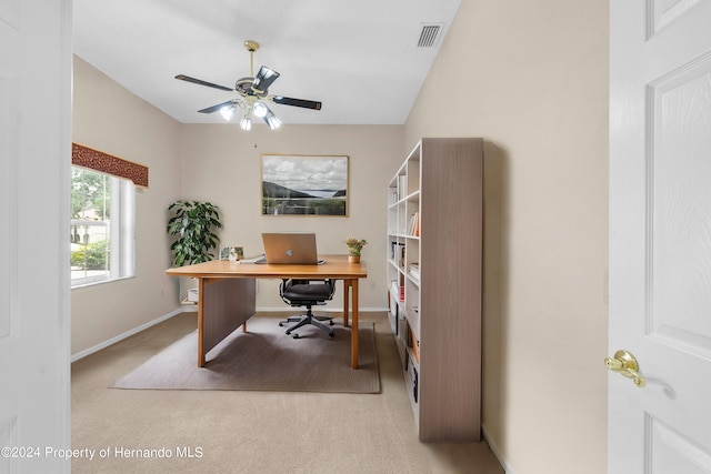 carpeted office space featuring ceiling fan