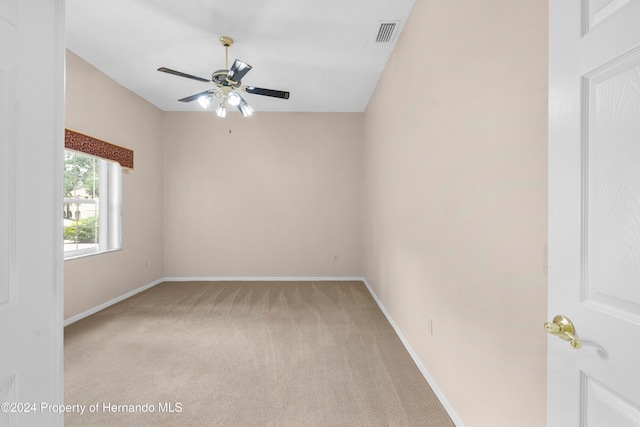 empty room featuring light colored carpet and ceiling fan