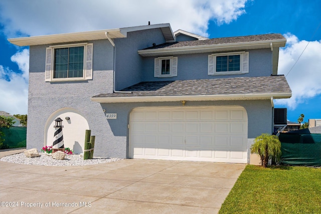 view of property with a garage and cooling unit