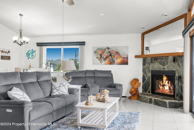 living room with a stone fireplace, light tile patterned flooring, a chandelier, and vaulted ceiling