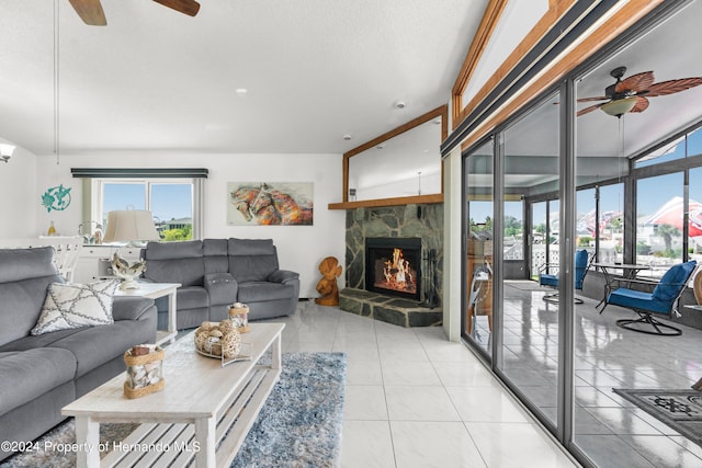 tiled living room with lofted ceiling, ceiling fan, and a fireplace