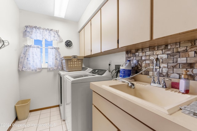 laundry area with washing machine and dryer, cabinets, sink, and light tile patterned flooring