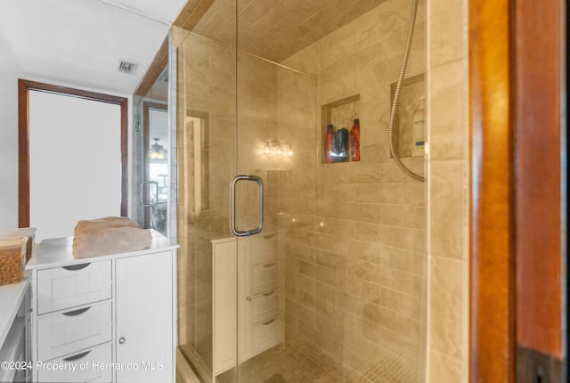 bathroom featuring a shower with shower door