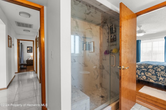 bathroom with walk in shower, ceiling fan, and tile patterned floors