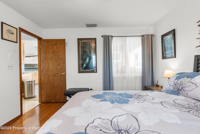 bedroom featuring light hardwood / wood-style flooring and a textured ceiling