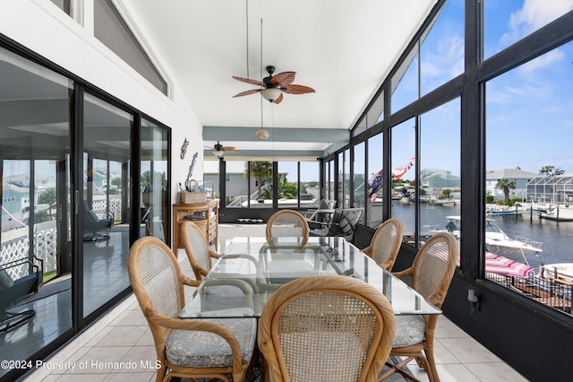 sunroom / solarium with ceiling fan, plenty of natural light, and a water view