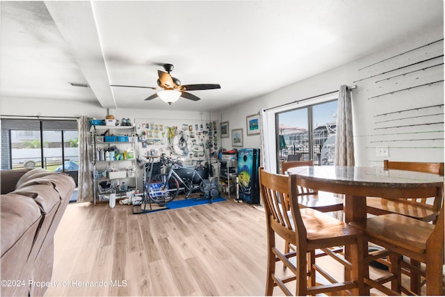 dining area with light wood-type flooring and ceiling fan