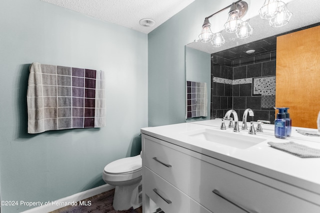 bathroom with wood-type flooring, vanity, toilet, and a textured ceiling