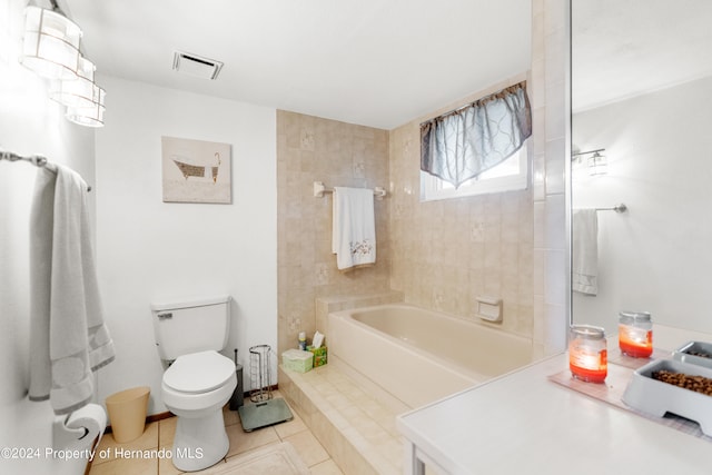 bathroom with toilet, a tub, and tile patterned flooring