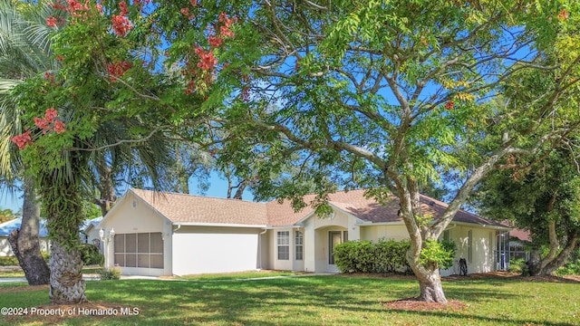 single story home featuring a garage and a front yard