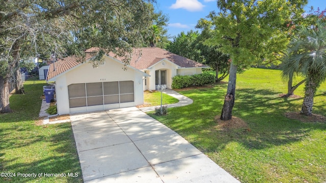 mediterranean / spanish house with a garage and a front lawn