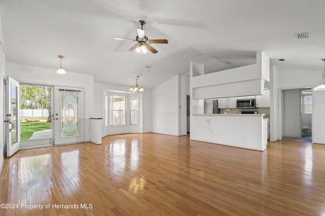 unfurnished living room with light hardwood / wood-style floors, ceiling fan with notable chandelier, and lofted ceiling