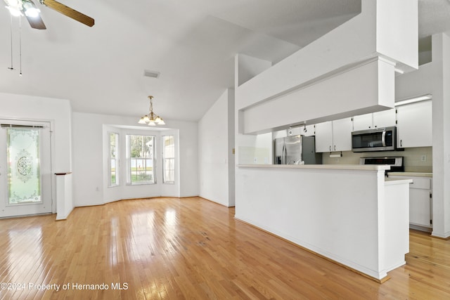 kitchen featuring ceiling fan with notable chandelier, light hardwood / wood-style flooring, backsplash, white cabinetry, and appliances with stainless steel finishes